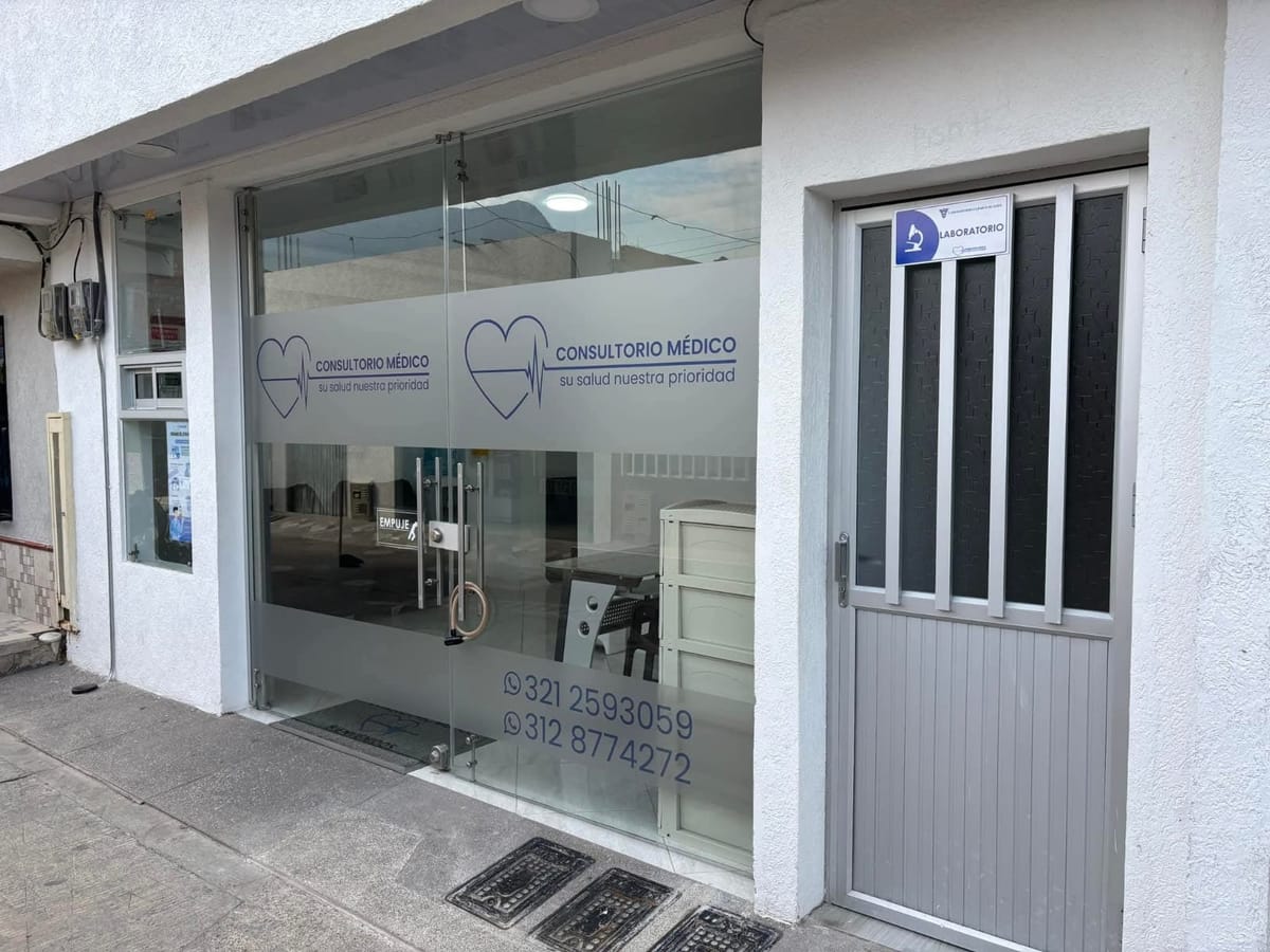 Fachada del Laboratorio Clínico Alahia en Supía: vitrina del consultorio médico con el logo del corazón y la puerta del laboratorio.